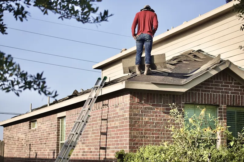 Professional roofer working on a residential roof in Le Ray
